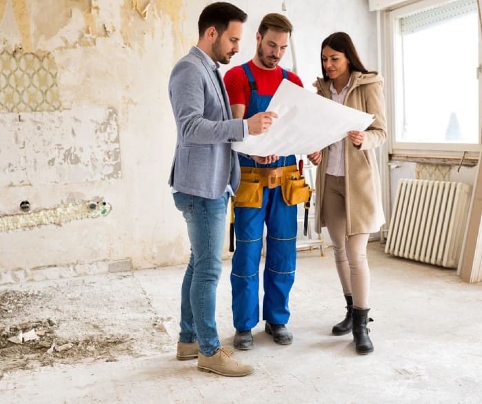 A group of people standing around looking at plans.